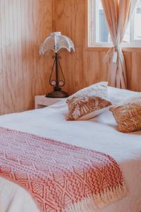 ein Schlafzimmer mit einem Bett mit einem Regenschirm darauf in der Unterkunft CABAÑAS TRAPEN in Puerto Montt