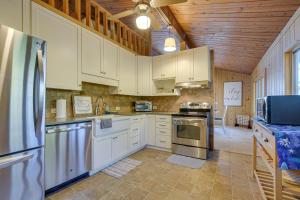 a kitchen with white cabinets and stainless steel appliances at Cozy Lakefront Cabin in Semora with Large Dock! in Semora