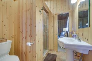 a bathroom with a white sink and a toilet at Cozy Lakefront Cabin in Semora with Large Dock! in Semora +22 photos