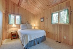 a bedroom with a bed in a wooden room at Cozy Lakefront Cabin in Semora with Large Dock! in Semora