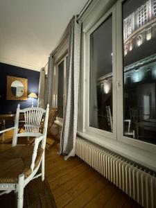 um quarto com uma janela, uma cadeira e uma mesa em Le Tiki de Notre-Dame - duplex vue Cathédrale em Boulogne-sur-Mer