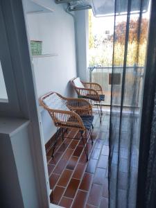 3 sedie sedute su un balcone con finestra di Apartman Vesna 4 persons a Njivice