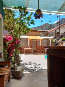 Elle offre une vue sur un bâtiment doté d'une terrasse avec des arbres. dans l'établissement Hostal Raymi, à Ollantaytambo