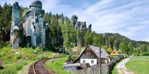 uma estação de trem nos trilhos em frente a uma montanha em Ubytování v Podkrkonoší em Úpice