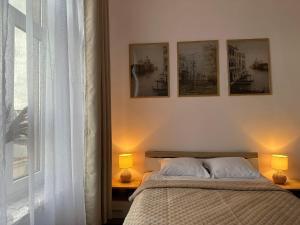 a bedroom with a bed with three pictures on the wall at Apartament Piaskowy Kołłątaja in Tomaszów Mazowiecki