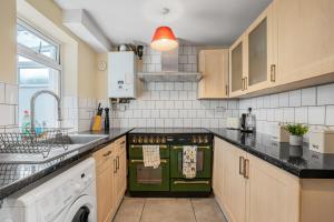 uma cozinha com um fogão verde e um lavatório em Emma's Central House & Parking em Nottingham