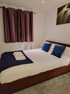 een slaapkamer met een groot bed met blauwe kussens bij Salford Quays Apartment, perfect location in Manchester