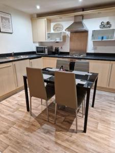 een keuken met een eettafel en stoelen bij Salford Quays Apartment, perfect location in Manchester