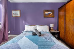 1 dormitorio con paredes de color púrpura y 1 cama en Emma's Central House & Parking en Nottingham