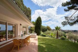a patio with a table and chairs on a lawn at Villa en Calonge con Gran piscina in Calonge