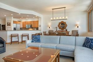 sala de estar con sofá azul y cocina en Beaver Creek Highlands Lodge 209 en Beaver Creek