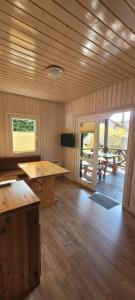 a cabin with wooden floors and tables and a patio at OW Plaża Klub domki in Dziwnów