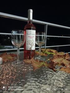 una bottiglia di vino e due bicchieri su un tavolo di Ikiesnafplio a Nauplia