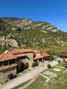 a building with a mountain in the background at Muntenia Inn Apartments and Suites in Kalavrita