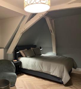 sypialnia z łóżkiem i krzesłem w pokoju w obiekcie Le Vieux Cèdre Grand Place w mieście Mons