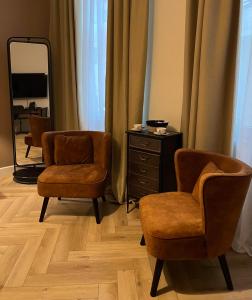 vestidor con 2 sillas y espejo en Le Vieux Cèdre Grand Place, en Mons