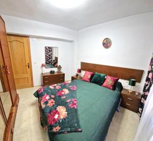 a bedroom with a green bed with pink pillows at Apartment Svetlana in Alicante