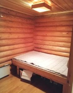 Habitación pequeña de madera con cama. en Romeo Lomamökki, en Lapua
