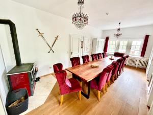 uma sala de jantar com uma mesa de madeira e cadeiras vermelhas em Familien Gruppen Villa EMG Osnabrück Bielefeld - Preußisch-Oldendorf em Preußisch Oldendorf