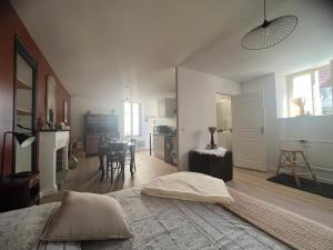 ein Schlafzimmer mit einem Bett und eine Küche mit einem Tisch in der Unterkunft L’Etape, cœur de ville in La Charité-sur-Loire