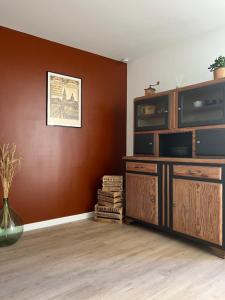 a living room with a large wooden entertainment center at L’Etape, cœur de ville in La Charité-sur-Loire +14 photos