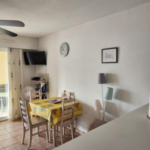 une salle à manger avec une table, des chaises et une horloge dans l'établissement les grimaudieres, à Grimaud