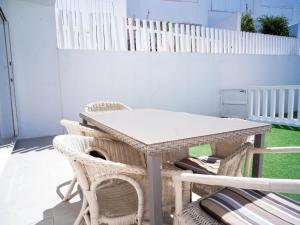 een tafel en stoelen op een patio met een hondenhok bij Chalet con piscina solo para familias in Conil de la Frontera