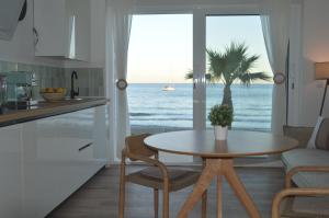 a kitchen and living room with a table and a view of the ocean at Excepcional Apartamento AMANECER CABO a pie de playa y mar,NUEVO A ESTRENAR in Alicante