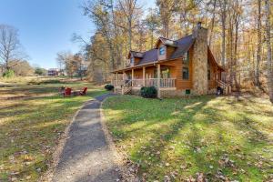 a log cabin in the woods with a dirt road at Smoky Mountain Cabin with Fire Pit Hike and Fish! in Murphy