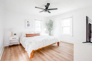 a white bedroom with a bed and a ceiling fan at Mid-Century Modern 2B Oakley with Fenced Yard and Offstreet Parking in Cincinnati