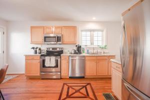 a kitchen with wooden cabinets and a stainless steel refrigerator at Mid-Century Modern 2B Oakley with Fenced Yard and Offstreet Parking in Cincinnati