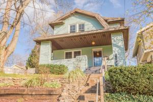 a green house with a brown roof at Mid-Century Modern 2B Oakley with Fenced Yard and Offstreet Parking in Cincinnati