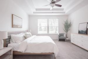 - une chambre blanche avec un lit et un ventilateur de plafond dans l'établissement Modern, Loveland Luxury Oasis by Trails, I-71, à Loveland