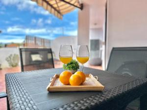 two glasses of wine and oranges on a table at Terracita de Luces in La Laguna