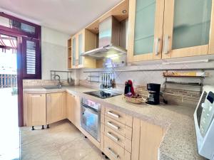 a kitchen with wooden cabinets and a stove top oven at Terracita de Luces in La Laguna