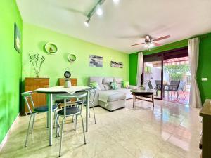 a living room with green walls and a table and chairs at Terracita de Luces in La Laguna