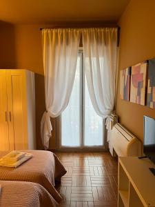 ein Schlafzimmer mit einem Bett und einem großen Fenster in der Unterkunft B&B Corso Porta Nuova 39 in Verona