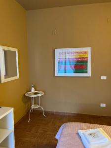 a room with a bed and a table and a painting at B&B Corso Porta Nuova 39 in Verona