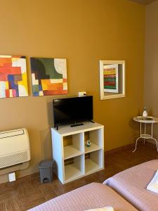 ein Wohnzimmer mit einem TV und einem weißen Schrank in der Unterkunft B&B Corso Porta Nuova 39 in Verona