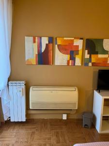 a room with paintings on the wall and a heater at B&B Corso Porta Nuova 39 in Verona