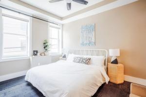 a white bedroom with a bed and a ceiling fan at Artist Gallery Downtown 2Bed 2Bath Condo in Cincinnati