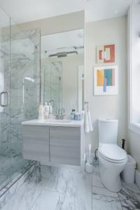 a white bathroom with a toilet and a shower at Artist Gallery Downtown 2Bed 2Bath Condo in Cincinnati