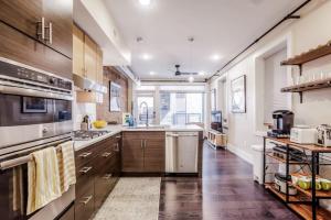 a large kitchen with wooden cabinets and a large window at Artist Gallery Downtown 2Bed 2Bath Condo in Cincinnati