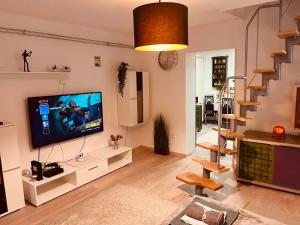 sala de estar con TV de pantalla plana y escalera en King House & Garden with AC and FREE PARKING POSSIBILITY, en Budapest