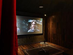 a room with a screen with a table in front of it at Hotel Wanderlive in Querétaro