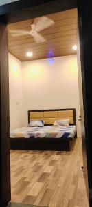 Cama en habitación con suelo de madera en Hotel Amrit shree, en Ujjain