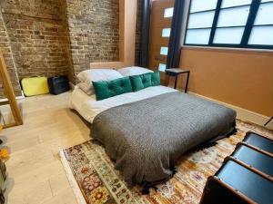 a bed in a room with a brick wall at Exposed Brick Flat Finsbury Park in London