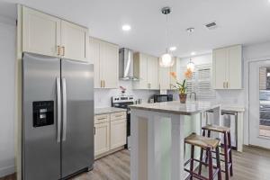a kitchen with a stainless steel refrigerator and white cabinets at Helena's Place, Exclusive End Unit Townhouse in Destin