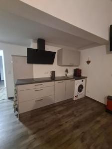 a kitchen with white cabinets and a washing machine at Wohnung mit 2 Schlafzimmern in Wutöschingen