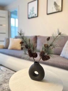 a black vase with pine cones in a living room at New Modern Apartments in the City Center in Narva +38 photos